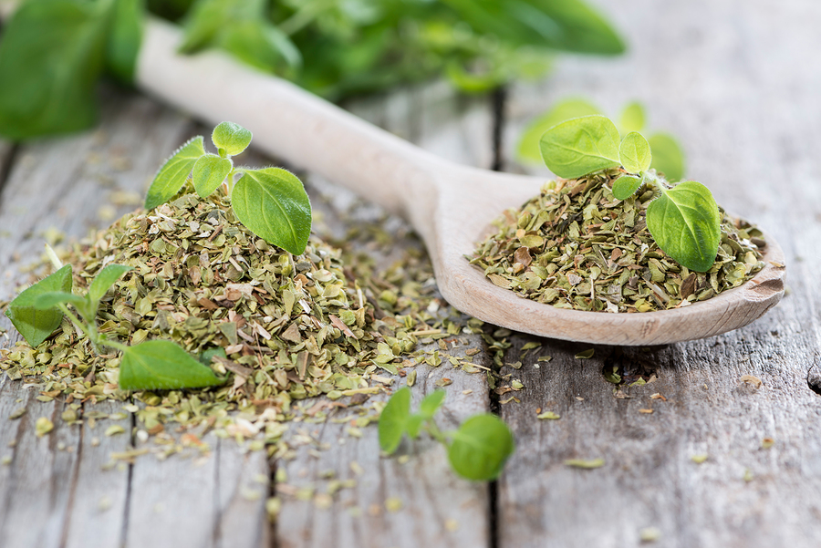 Oregano on a wooden spoon (against wooden background) ** Note: Shallow depth of field