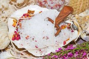 Healthy marine bath salts rich in minerals mixed with dried aromatic rose petals for a luxury bath treatment at a spa