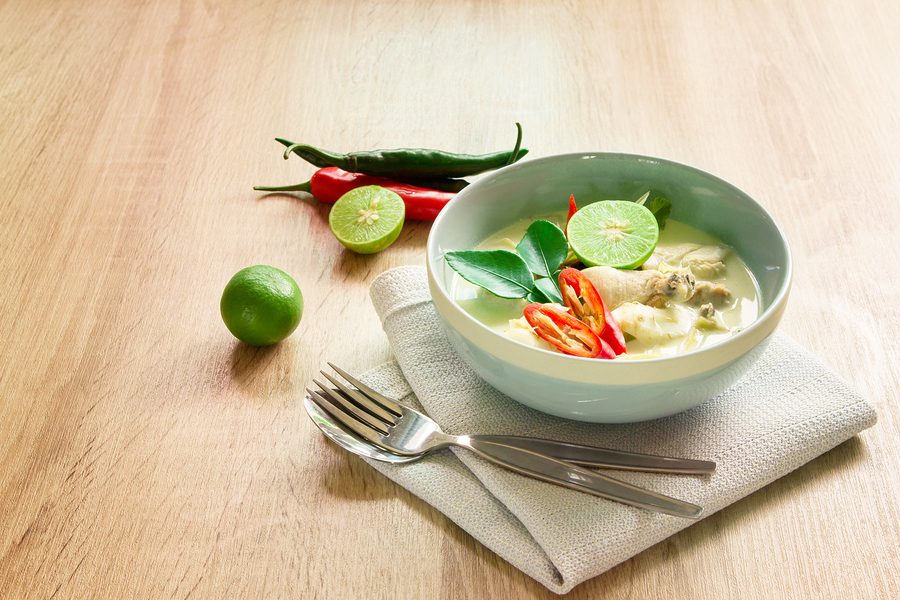 Spicy creamy coconut soup with chicken Thai food called Tom Kha Gai on wooden table